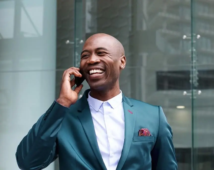businessman who leverages organic growth on his fast website talking on the phone and smiling